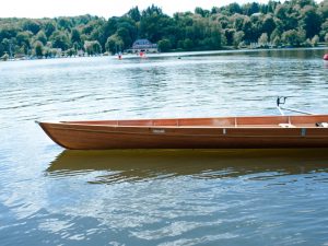 Ein leeres Ruderboot ragt in den Baldeneysee hinein, sein Name ist "Ruhr"